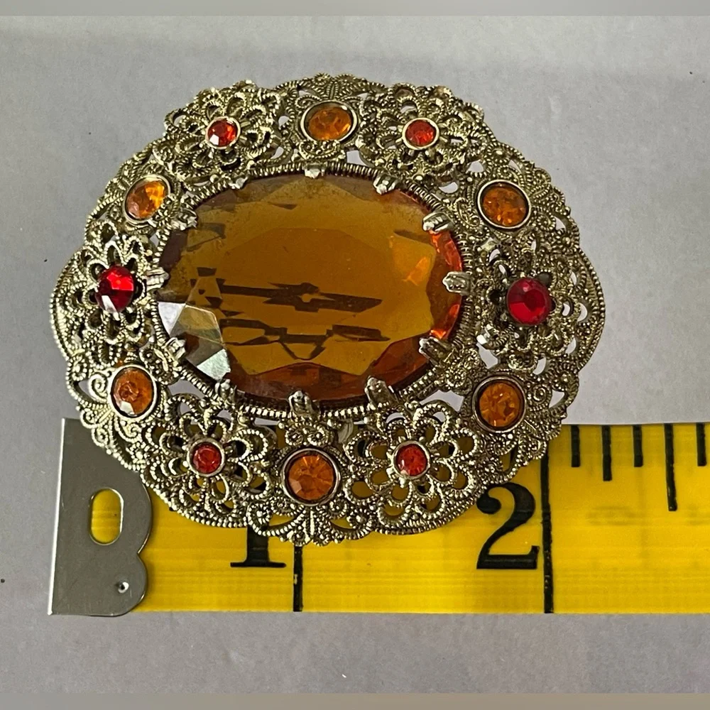 Vintage West Germany brooch featuring a large amber topaz glass filigree gold